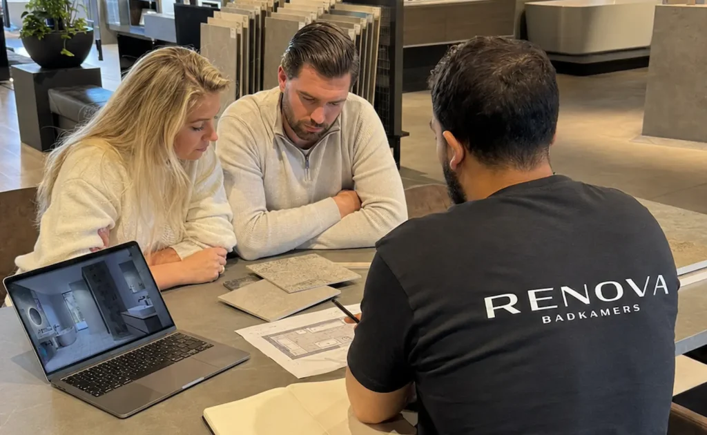 Klanten bespreken hun badkamerontwerp met een adviseur van Renova Badkamers in de showroom.