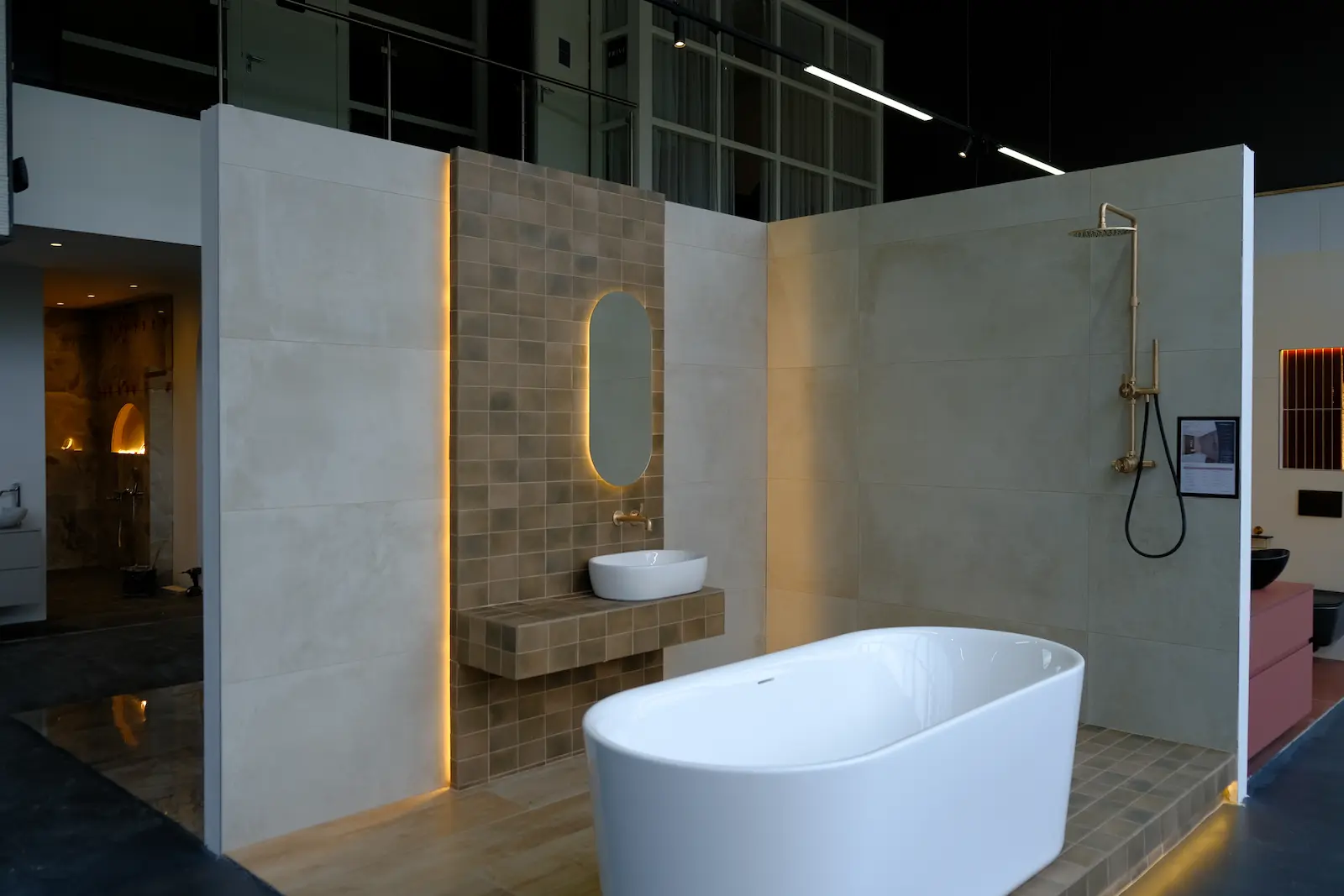 Beige showroom badkamer met vrijstaand bad, inloopdouche en gouden kranen