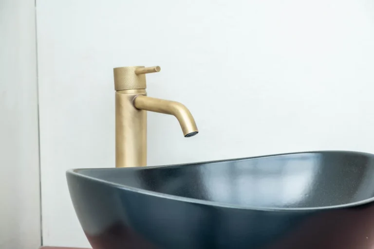 Wastafelkraan in geborsteld messing boven een zwarte waskom in de Renova badkamershowroom