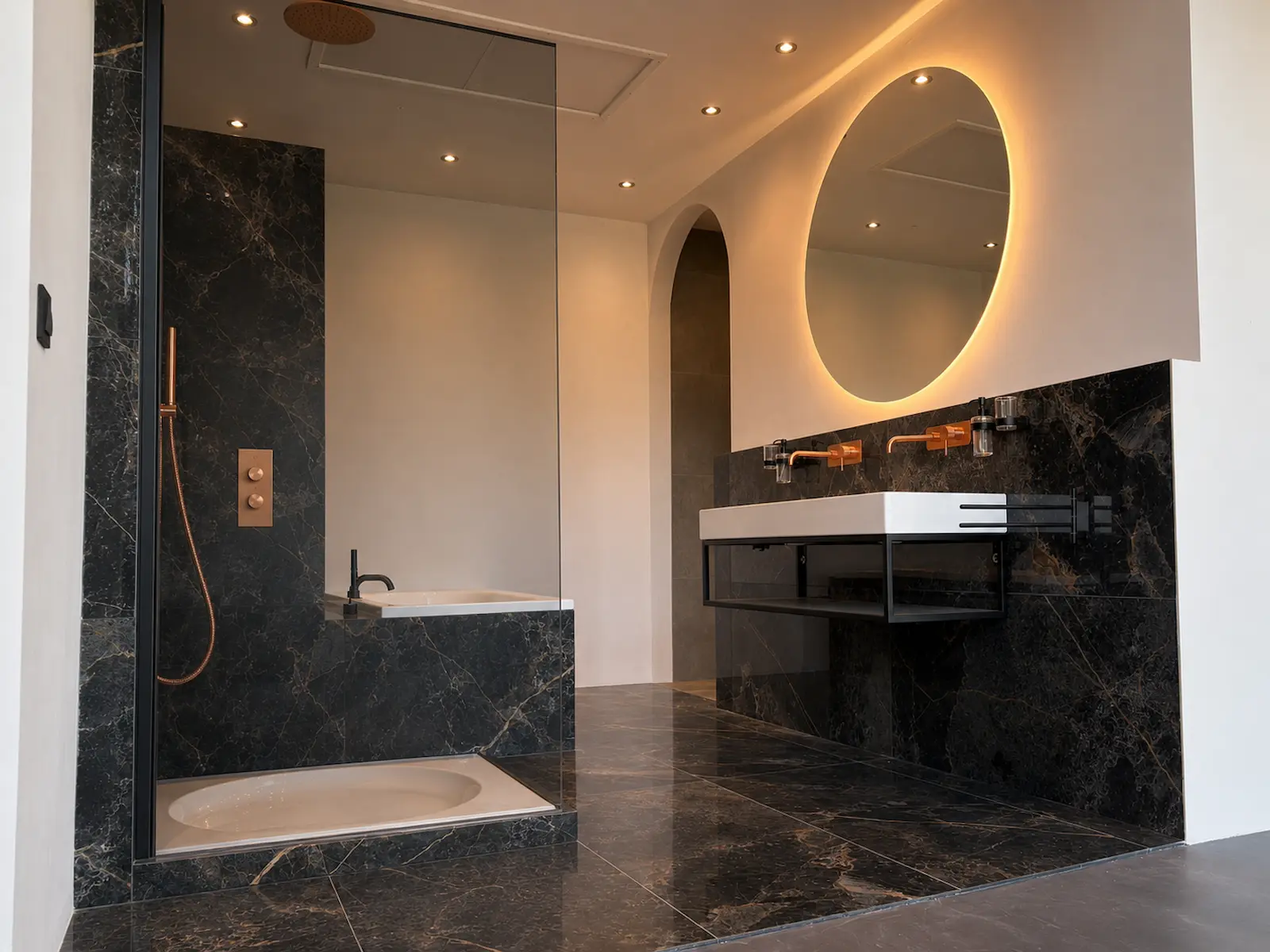 Luxe zwarte marmeren badkamer met inloopdouche en verlichte spiegel