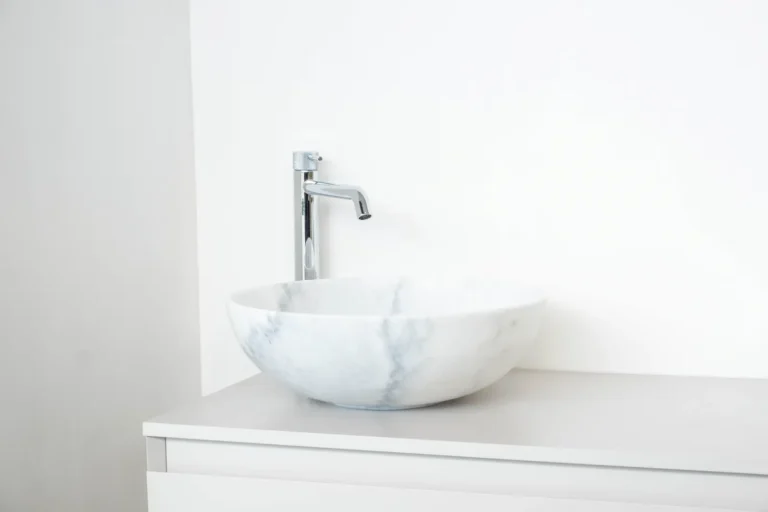 Witte marmerlook waskom met hoge chromen kraan in de Renova badkamershowroom
