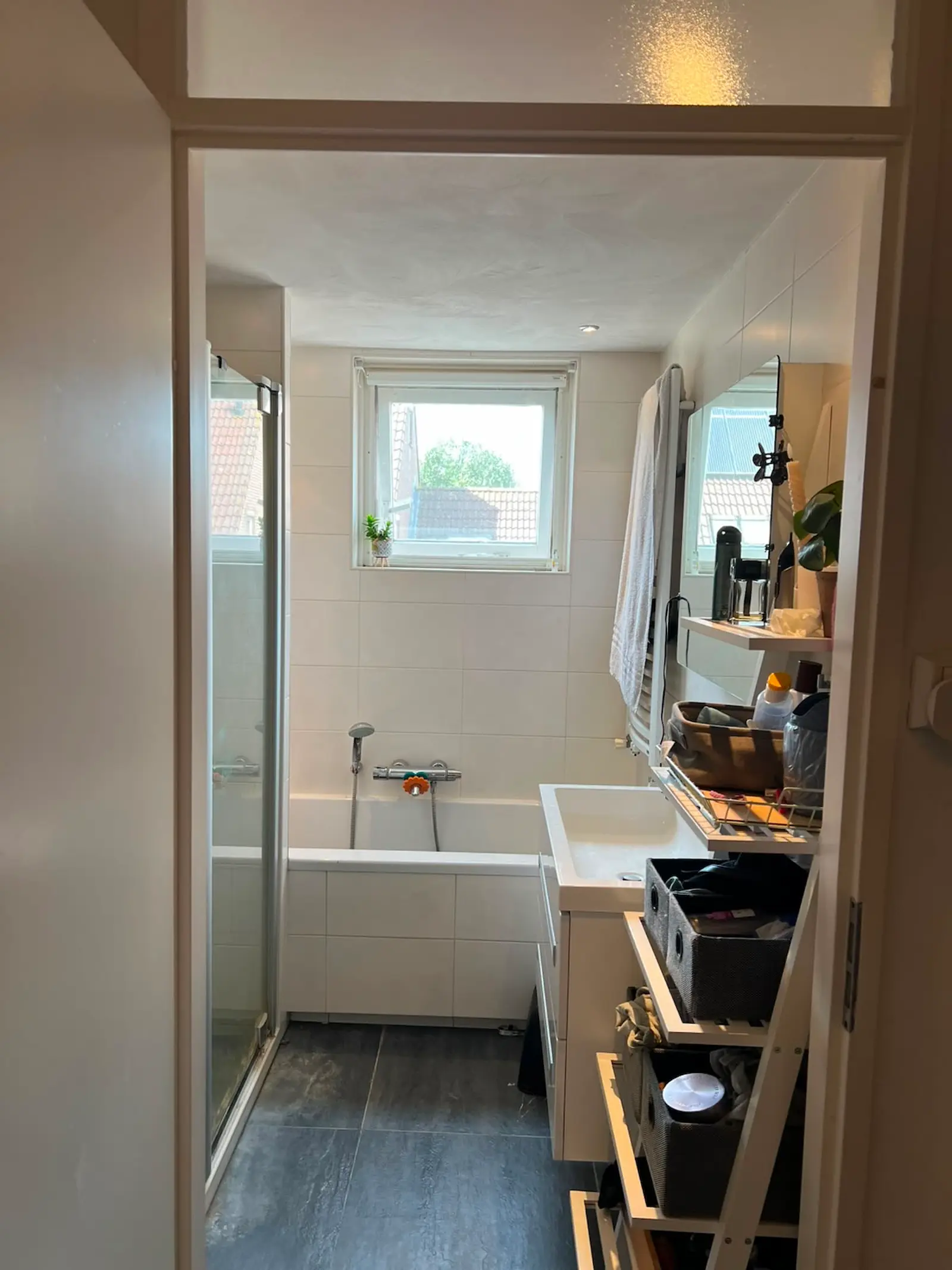 Oude badkamer met ligbad, douchecabine en beperkte opbergruimte vóór de complete badkamerrenovatie